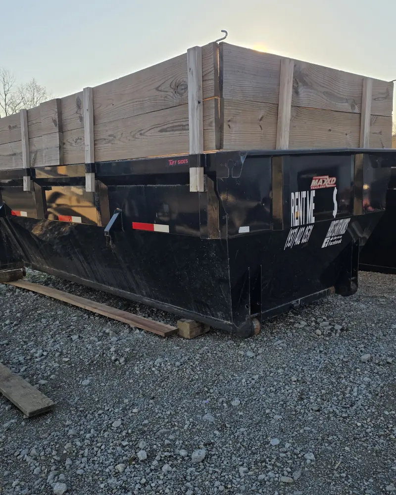Hurst Earthworks 20-yard roll-off dumpster on gravel with the RENT ME sign