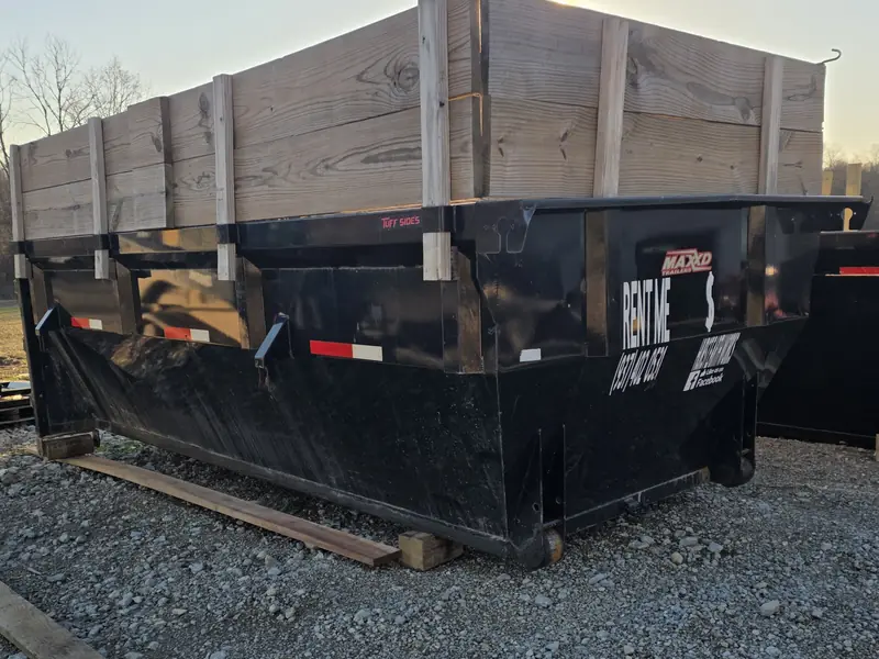 Hurst Earthworks dumpster resting on gravel with boards underneath